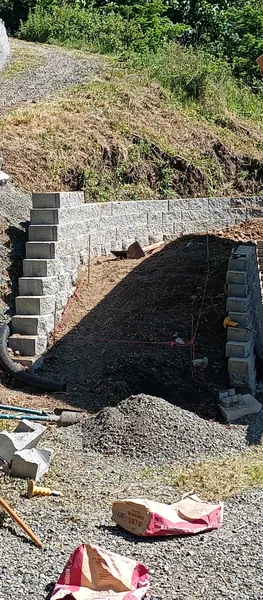 The stone wall by the pavilion, gravel drive beyond.